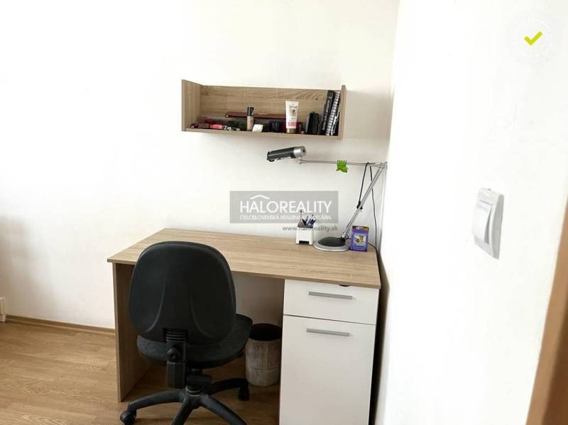 Íróasztal polccal és irodai szék a háromszobás lakásban.