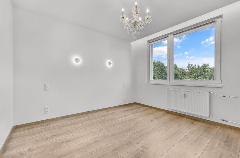 Üres szoba fa padlóval, csillárral és nagy ablakkal, 4 szobás lakás.