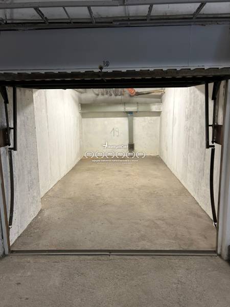 Üres garázs tér betonpadlóval és falakkal, garázsok.