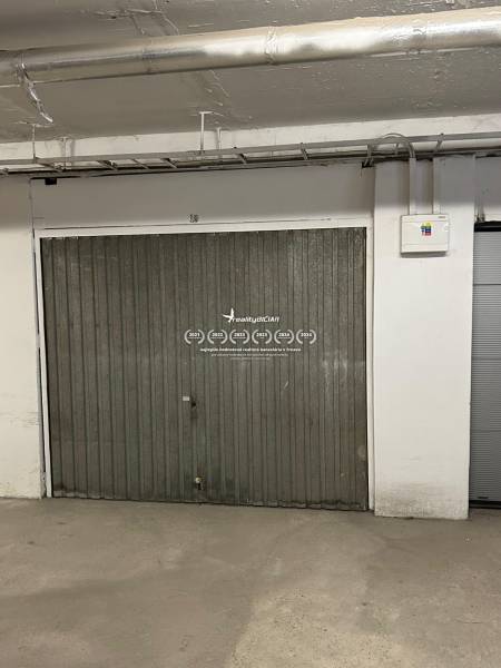 Fémkapu a garázsban csövekkel és elektromos elosztószekrénnyel a falon.