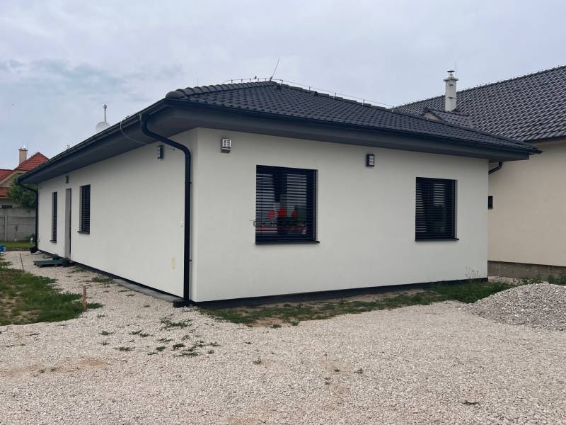 Családi ház fehér homlokzattal, szürke tetővel a Veselé utcán.