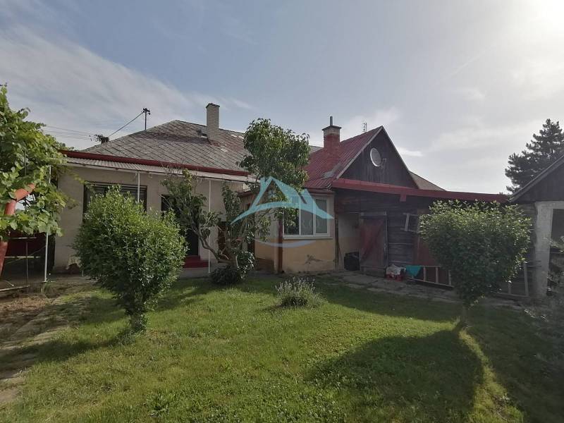 Családi ház Hrkovce-ben kerttel, bokrokkal és fa előtetővel.