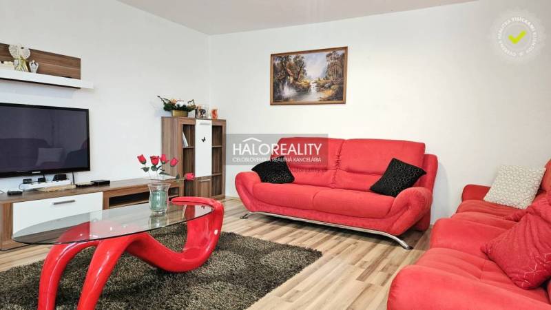 Családi ház nappalija piros kanapékkal és modern bútorokkal.