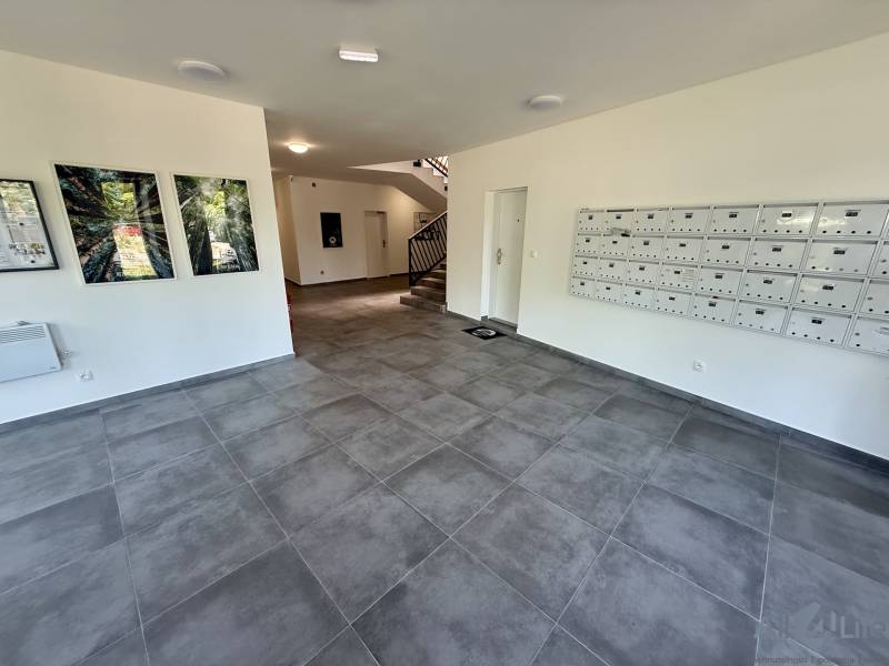 Belső tér csempével és lépcsővel, postaládák, 2 szobás lakás.