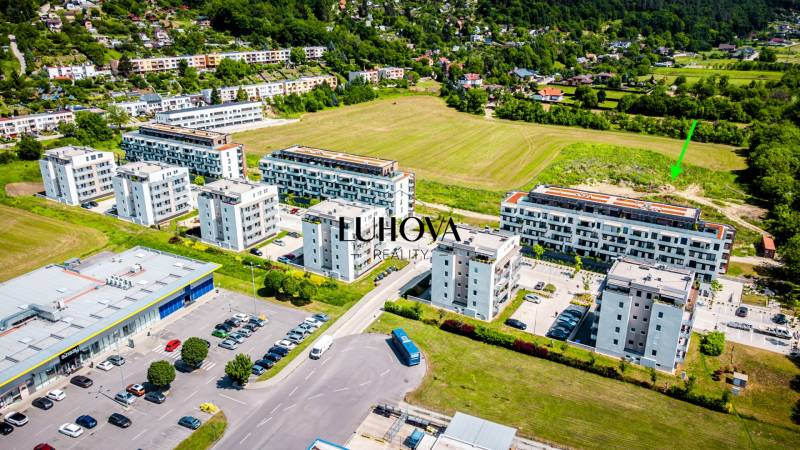 Légi felvétel a púchovi Dlhé lúky lakótelepről és parkolóról, kilátással egy kétszobás lakásra.