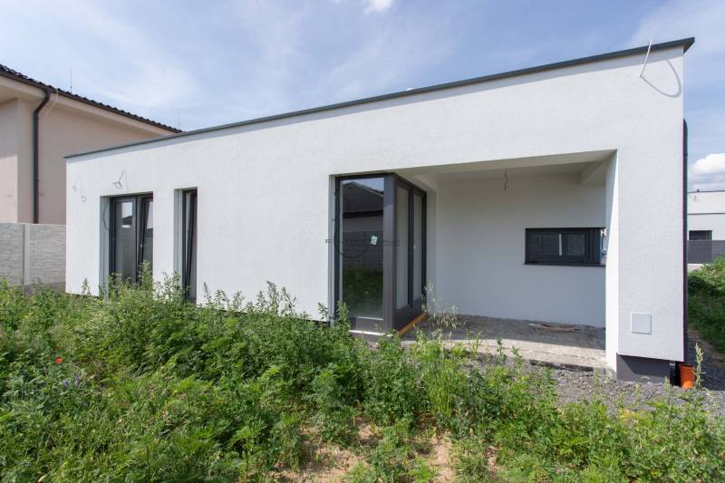 Családi ház Zohorban fehér homlokzattal és kerttel a külső részen.