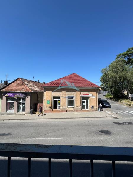 Kereskedelmi helyiségek Ipolyság főterén, piros tetővel és kék éggel.