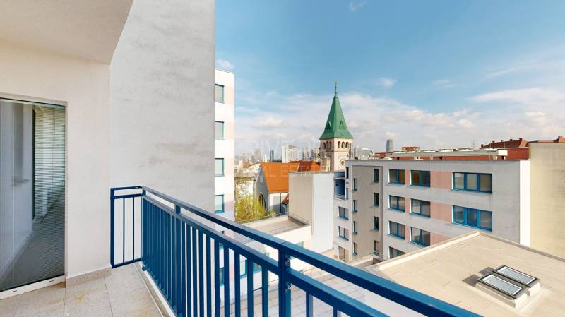 Kilátás az erkélyről a templomtoronyra és Pozsony panorámájára egy háromszobás lakásban.