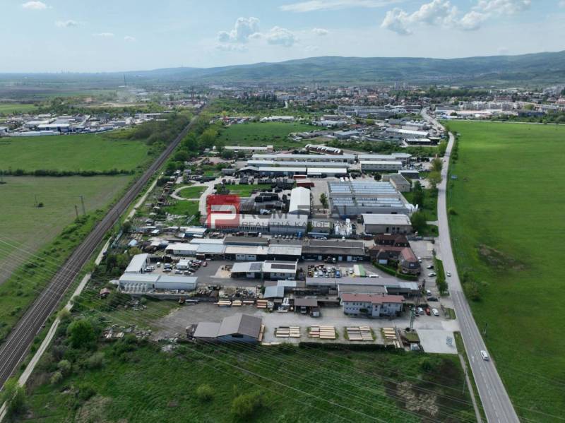 Légi felvétel a természet által körülvett üzleti területekről a Pezinok-i Šenkvická úton.