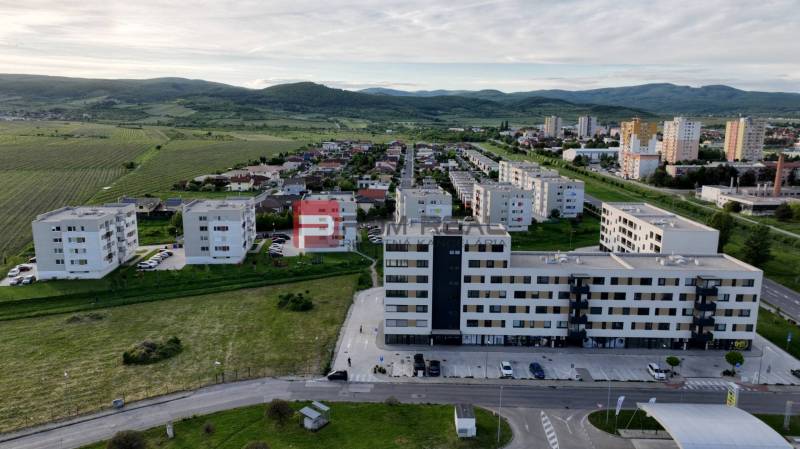Kereskedelmi helyiségek a pezinki Obchodná utcában, zöldövezet és lakóövezetek veszik körül.