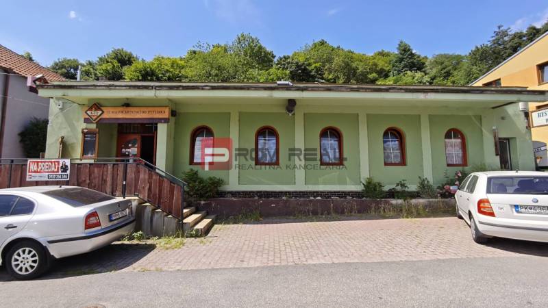 Épület fehér autókkal a parkolóban a Gasztro térben, Podhradíban, Szentgyörgyön.