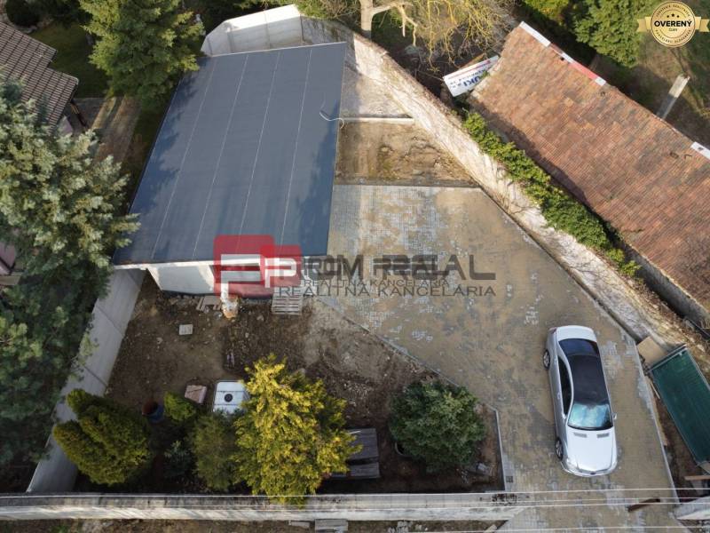 Családi ház udvara Pezinkben, parkoló autóval és garázzsal.