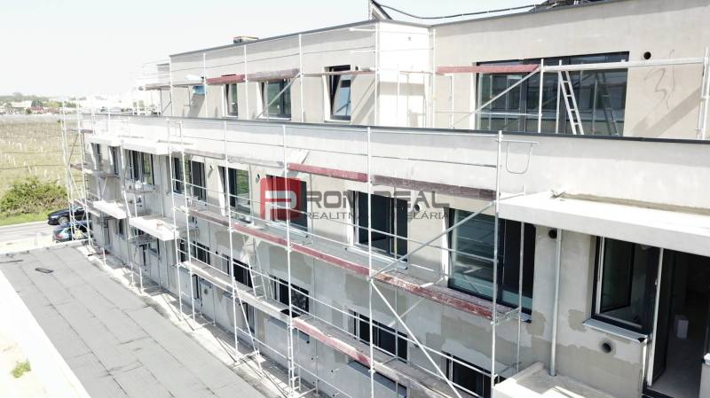 Épület a Limbašská úton, Bazinban, a 3 szobás lakások építése alatt állványzattal.