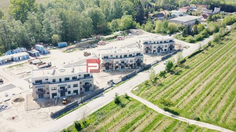Új épületek a Limbašská úton, Pezinokban, zöldövezet és építés alatt álló területek által körülvéve.