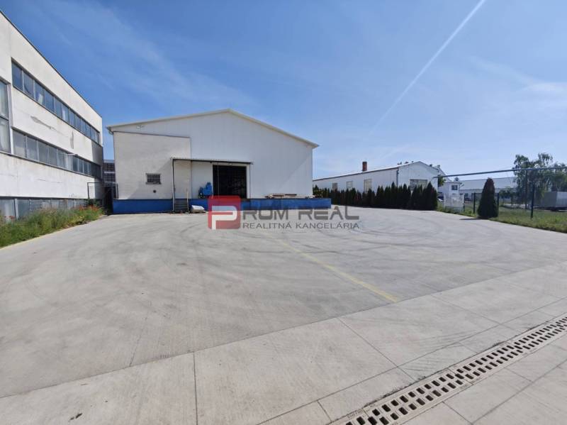 Raktárak és csarnokok a Modrai Šúrska utcában nagy betonparkolóval.