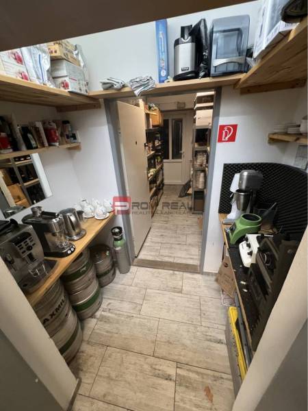 Tárolóhely polcokkal, hordókkal és kávéfőzőkkel kereskedelmi helyiségekben.