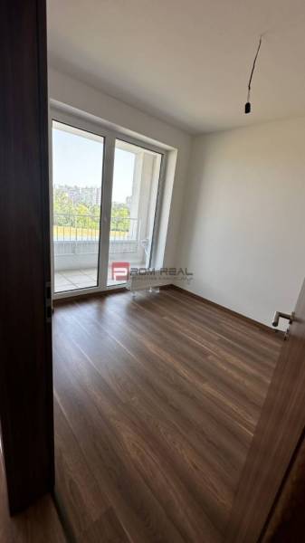Szoba fa padlóval és erkéllyel egy 2 szobás lakásban.