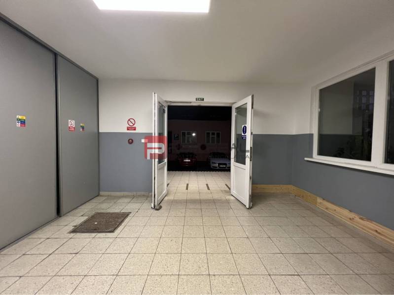 Bejárati folyosó a raktárak és csarnokok belsejében, kijárattal a parkolóhoz.