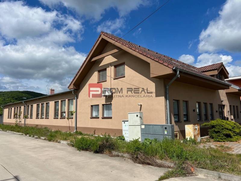 Gyártóhelyiségek a Pozsony III. kerületében, az Új utcában, kék égbolttal és zölddel.