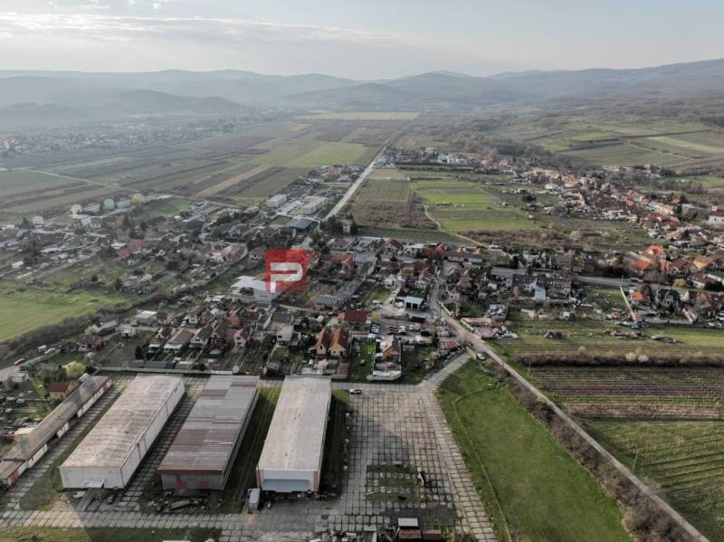 Kilátás a Pezinska utcai Vinosady gyártóhelyiségeire, amelyeket szőlőültetvények vesznek körül.