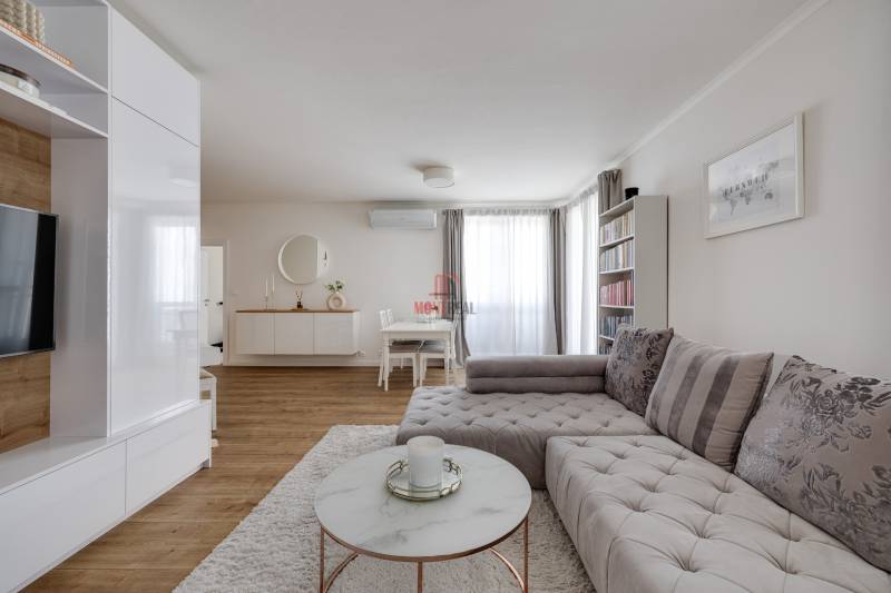 Nappali egy háromszobás lakásban stílusos kanapéval és minimalista bútorokkal.