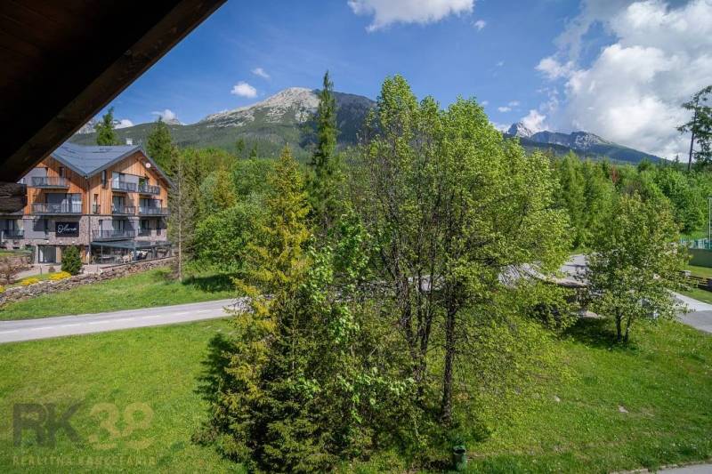 Kilátás egy üdülő apartmanból a Magas-Tátrában, hegyekkel és zöld fákkal.