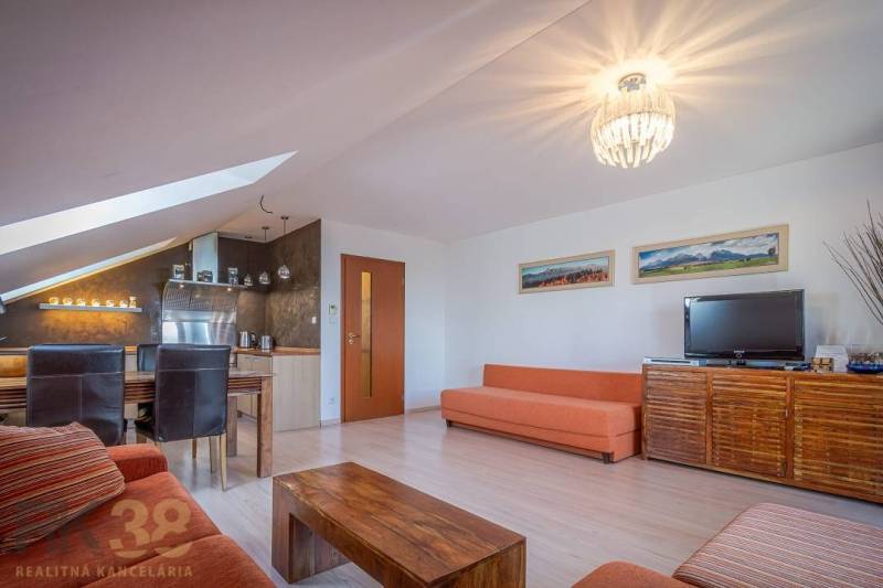 Nappali rekreační apartman kanapékkal, étkezőasztallal és televízióval.