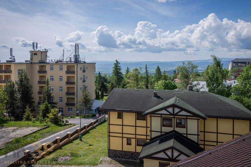 Épületek a gyönyörű Magas-Tátrában, Rekreációs apartman zölddel és hegyekkel körülvéve.