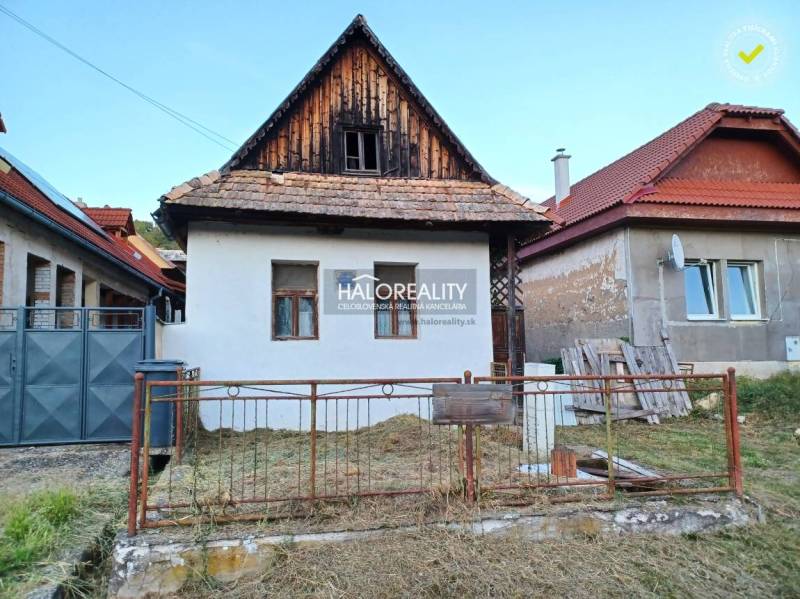 Családi ház Ladzanyban hagyományos építészettel, fehér homlokzattal és ferde tetővel.