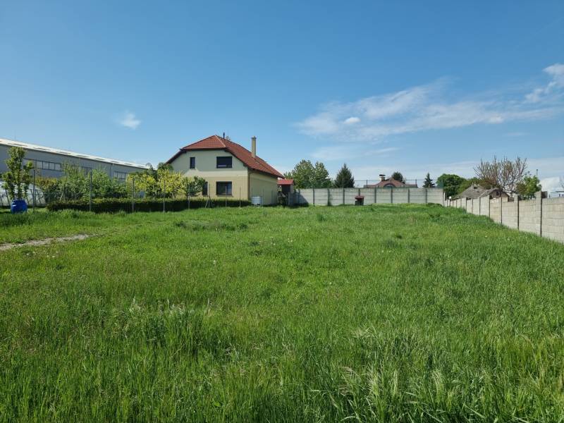 Pozemky - lakóhely Cabaj-Čáporban füves területtel és háttérben házzal.