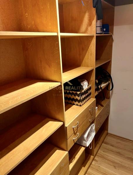 Tárolóhely fa polcokkal és fiókokkal egy kétszobás lakásban.
