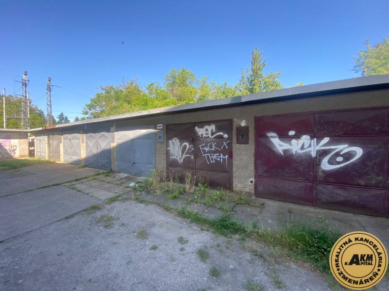 Garázsok Zólyomban, graffiti a kapukon, zölddel és betonfelülettel körülvéve.