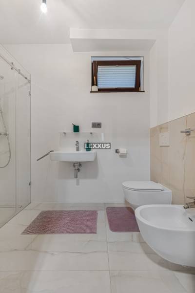 Fürdőszoba családi házban mosdóval, zuhanyzóval, WC-vel és bidével.