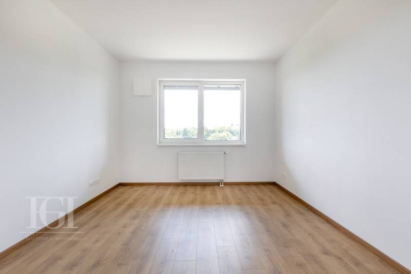 Üres szoba fa padlóval és nagy ablakkal egy háromszobás lakásban.