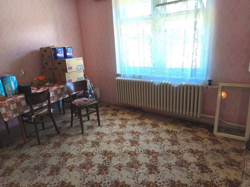 Soba v rodinnom dome s kobercom a stolom so stoličkami.
