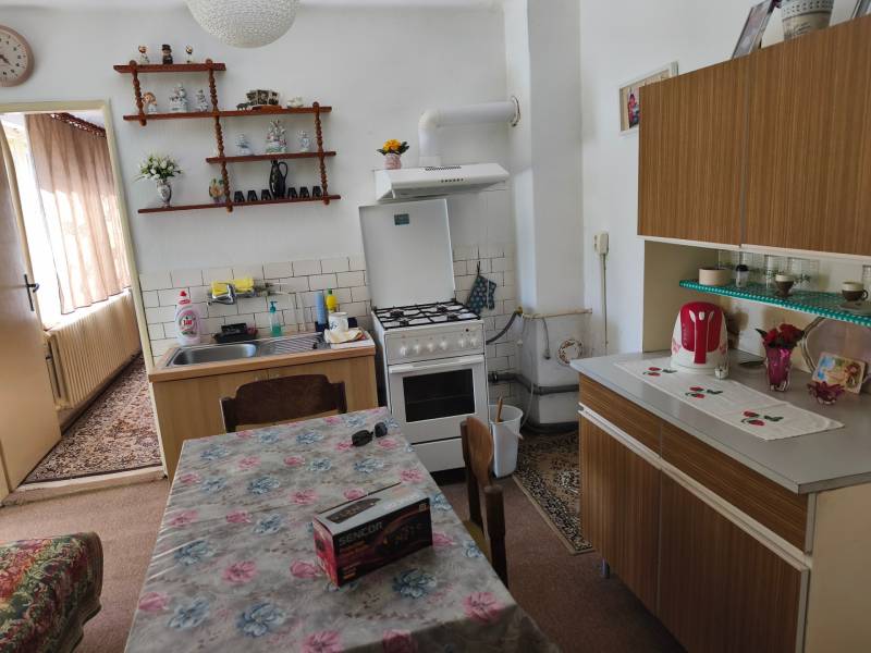 Konyha egy családi házban étkezőasztallal, konyhapulttal és dekorációkkal a polcon.