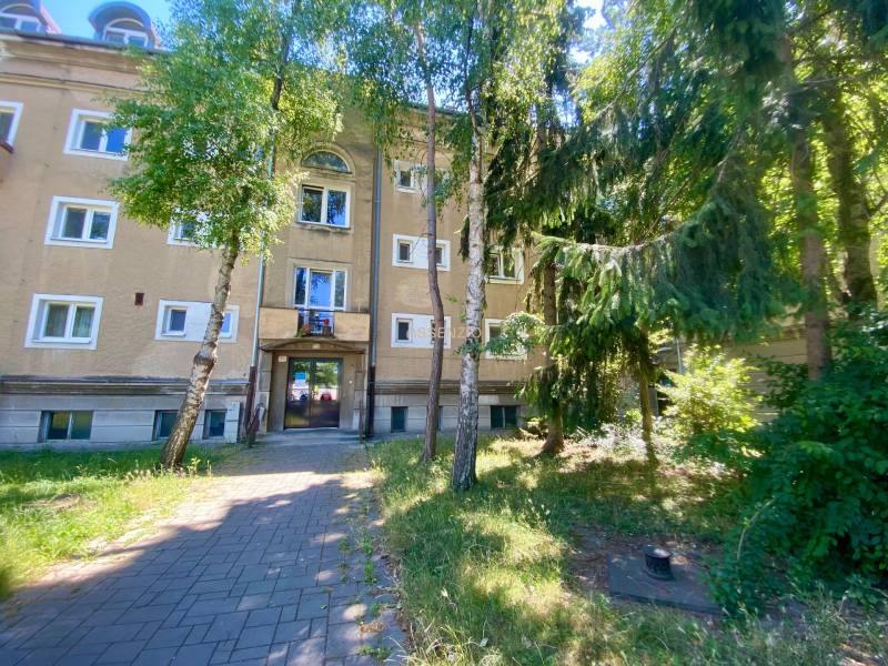 A Študentská utcai lakóház Nagyszombatban fákkal és zöld kerttel körülvéve.