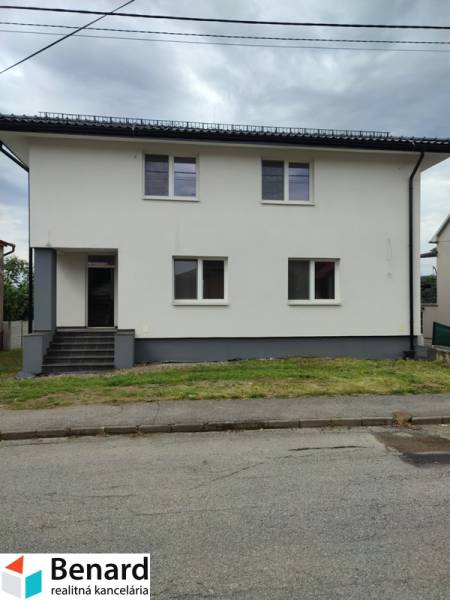 Családi ház a Nezabudova utcában, Sabinovban, fehér homlokzattal és szürke tetővel.