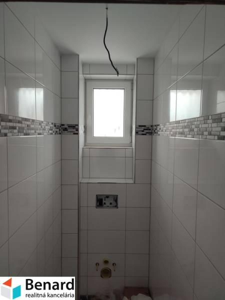 Fürdőszoba családi házban burkolattal és ablakkal, szaniterek nélkül.