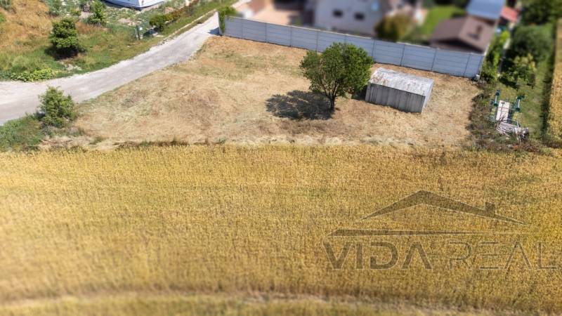 Nyugodt lakótelek Dunajská Lužná-ban, fedett parkolóval és fával.