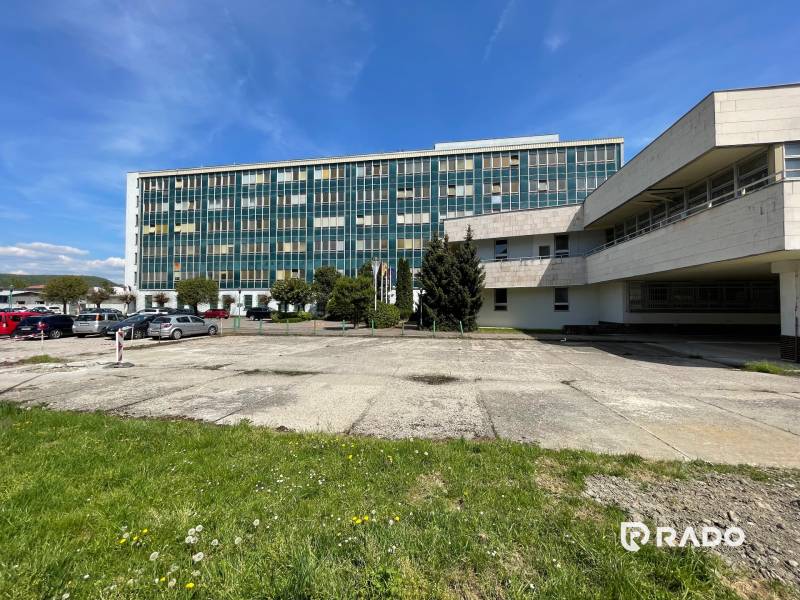 Irodaház a K výstavisku utcában, Trencsén városában, parkolóval és zöldterülettel.