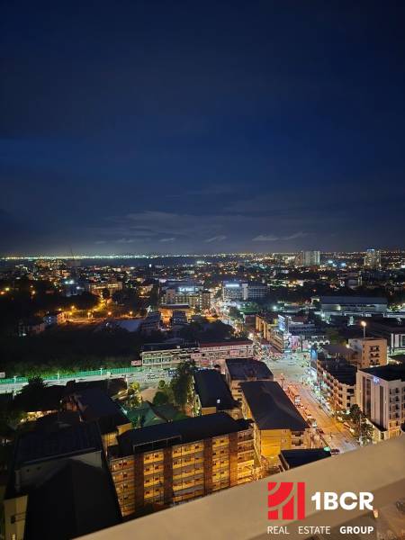 Pattaya éjszakai panorámája, kilátás egy egyszobás lakásból a kivilágított városra.