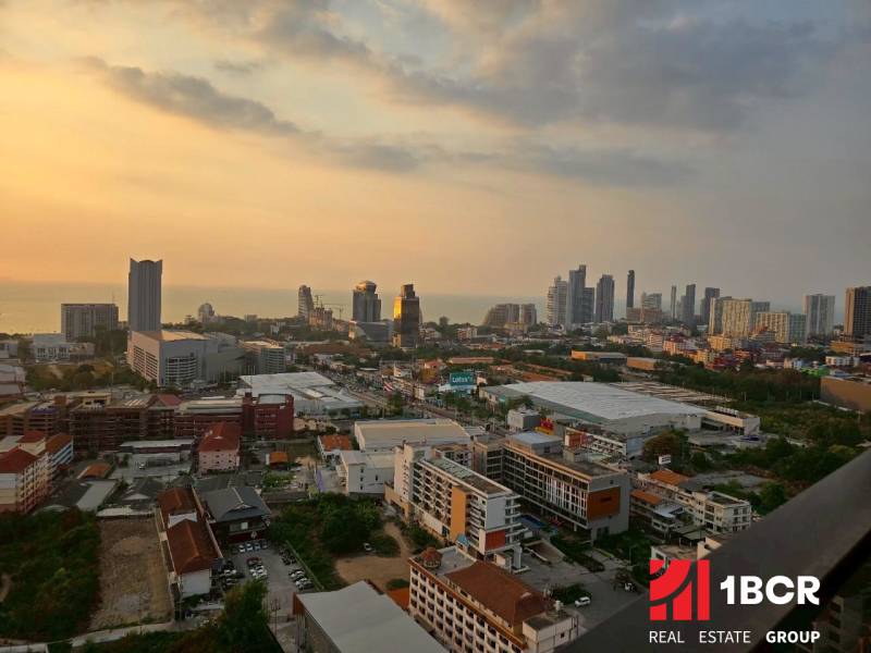 Naplemente kilátás a város panorámájára egy háromszobás lakásból Pattayában.