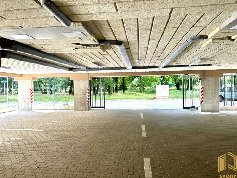 A garázsajtók nyitva vannak, kilátással a környező zöld területre.