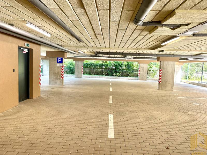 Parkolóház akadálymentes bejárattal, világítással és kijelölt parkolóhelyekkel.