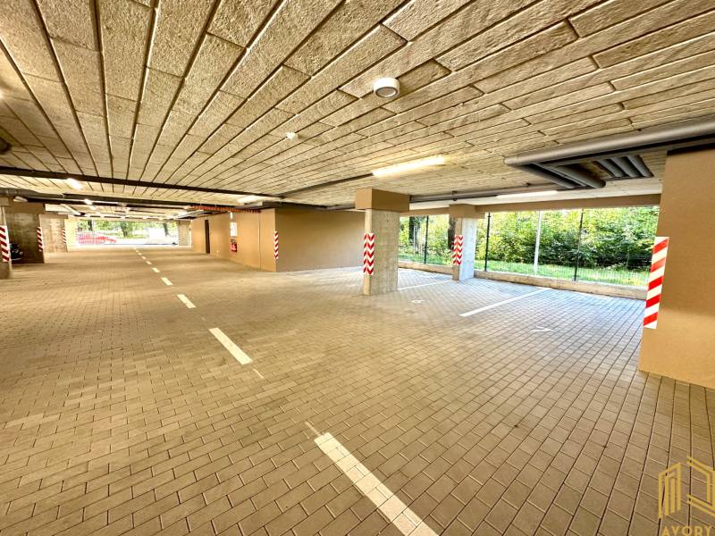 Garázsok lámpákkal, parkolóhelyekkel és oszlopokkal, Senica, Sadová, kilátás a zöldre.