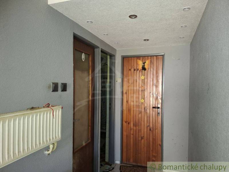 Családi ház előszobája faajtóval és radiátorral.
