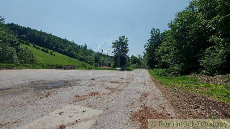 Parkoló, amelyet erdők és rétek vesznek körül Stará Myjavában, üzleti helyiségek közelében.