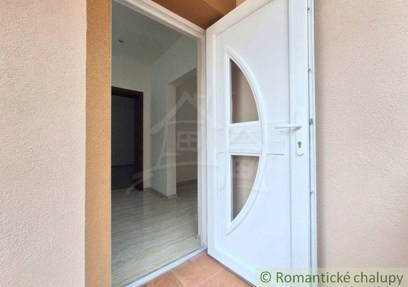 A komáromi családi ház bejárati ajtaja, csempézett padlóval és világos folyosóval.