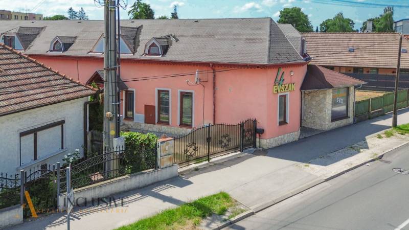 Családi ház Gyulu Szabóa utcában Dunaszerdahelyen rózsaszín homlokzattal és kő részletekkel.